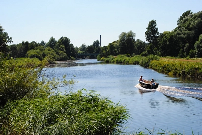 Zu sehen ist die Hamme, darauf schwimmend ein schmales Boot mit Motorantrieb, drumherum gibt es viele grüne Pflanzen.&nbsp;&copy;&nbsp;Gemeinde Ritterhude