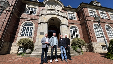 Herr Kuck mit Norbert Wellbrock, Rainer Lotze und Jan Sörnsen vor dem Rathaus Ritterhude bei blauem Himmel